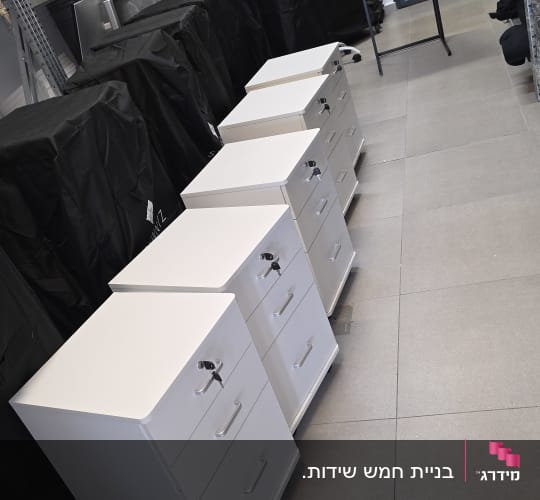 ארבעה ארונות מגירות לבנים בחדר אחסון